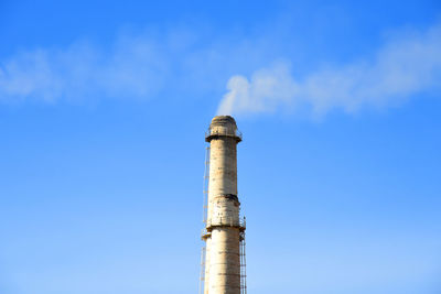 Low angle view of smoke stack against sky