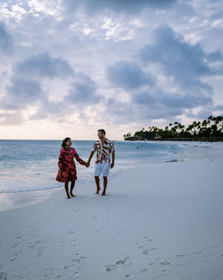 People on beach against sky