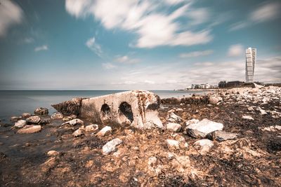 Rocks on beach against sky