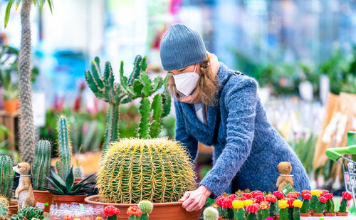 Midsection of woman with flowers on plants