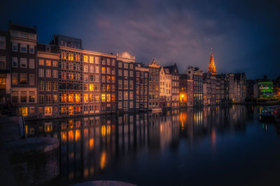 Illuminated cityscape against sky at night