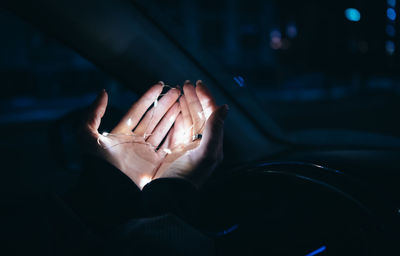 Close-up of woman hands holding illuminated lighting equipment