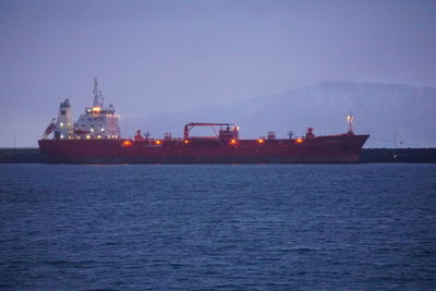 View of illuminated ship in sea against sky