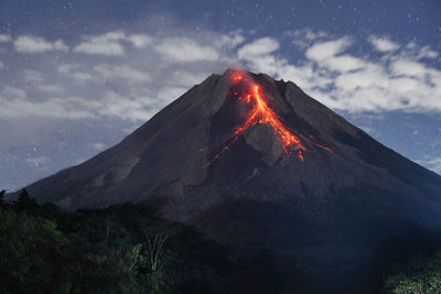 View of illuminated volcanic mountain against sky