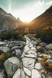 Stream flowing through rocks against sky