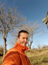 Portrait of man with arms raised against sky