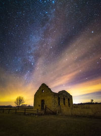 Built structure on field against sky at night