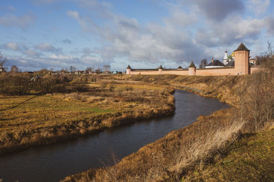 Scenic view of river amidst field against sky