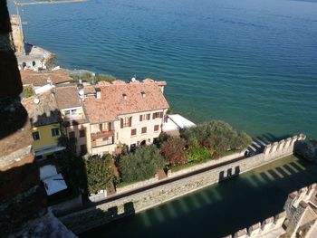 High angle view of buildings by sea against sky