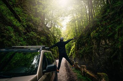 Happy man and car in canyon during summer