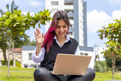 Smiling young woman using mobile phone