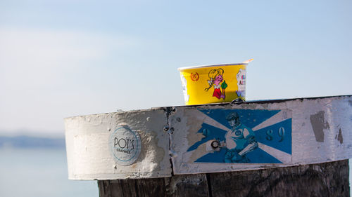 Low angle view of text on wood against sky