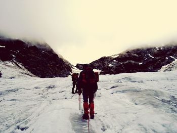 Rear view of person standing on snow covered landscape