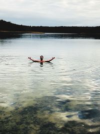 Man surfing in lake against sky