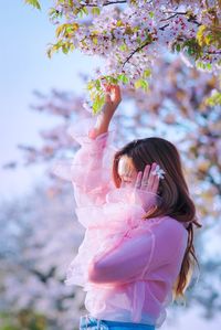 Beautiful woman touching cherry tree
