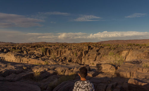 Man standing on landscape against sky