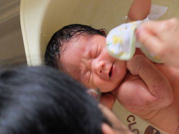 Man bathing baby boy in bathroom