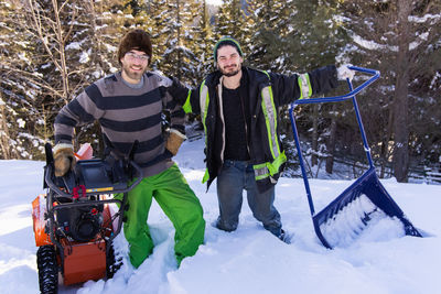 Full length of friends standing on snow covered mountain