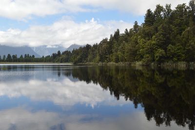 Scenic view of lake by trees against sky