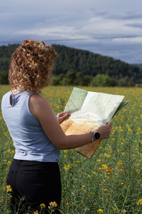 Rear view of woman standing against sky