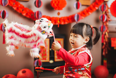 Girl holding lantern sitting at home