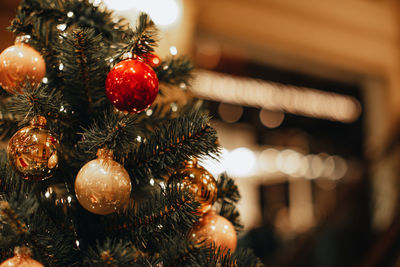 Golden and red christmas balls hanging on the christmas tree. bokeh magic effect. festive winter