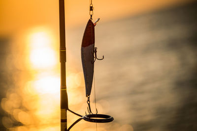 Close-up of fishing net against sky during sunset