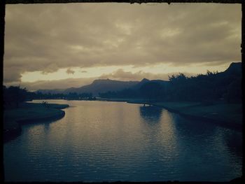 Scenic view of river against cloudy sky