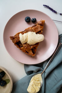 High angle view of apple pie cake in plate on table with ice cream 