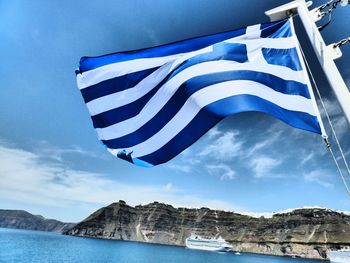Low angle view of flag against blue sky