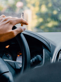Close-up of man smoking cigarette in car