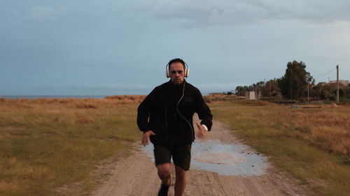 Man with headphone running outdoor during rain day