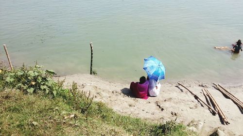 Rear view of woman sitting on beach