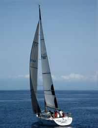 Sailboat sailing on sea against sky