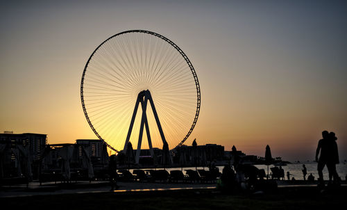 Silhouette ferris wheel against sky at sunset