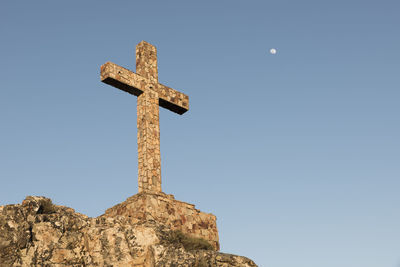 Low angle view of cross against clear sky