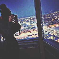 Woman standing on illuminated city at night