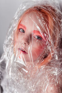 Close-up portrait of a young woman in a plastic bag