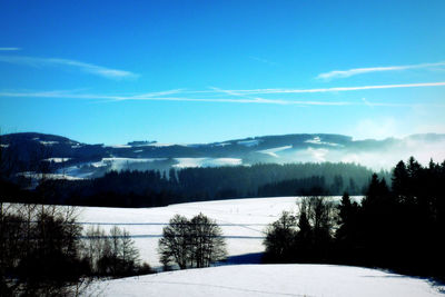 Scenic view of snow covered field against sky