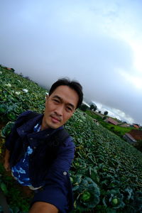 Portrait of young man standing against plants