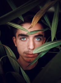 Portrait of young man with leaves