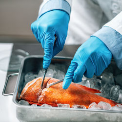 Quality assessment of raw fish. microbiologist cutting sample of sea fish in laboratory