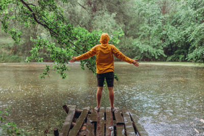 Full length of child standing on lake in forest