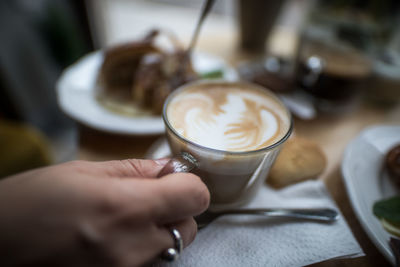 Close-up of hand holding coffee cup