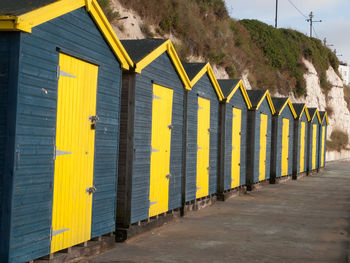 Row of yellow huts on road by building