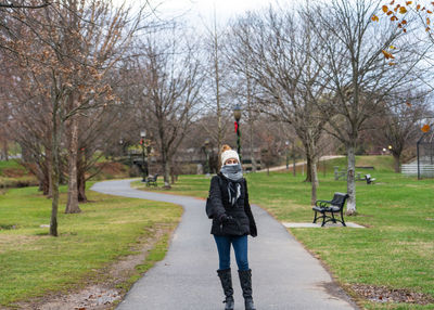 Front view of woman walking on footpath in park