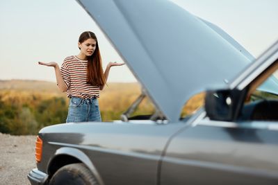 Side view of woman holding car