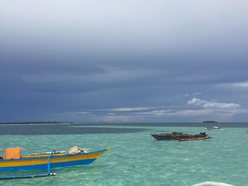 Boats moored in sea against sky