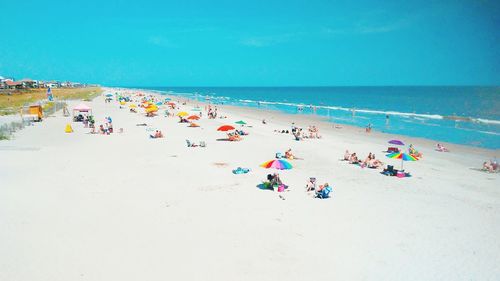 Group of people on beach against sky