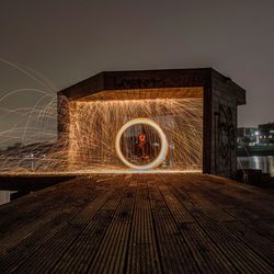 Blurred motion of person on footbridge against sky at night